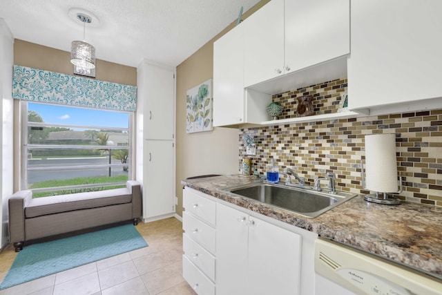 kitchen with pendant lighting, backsplash, white cabinets, white dishwasher, and sink