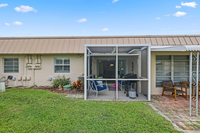 rear view of property with a lanai, a yard, and a patio