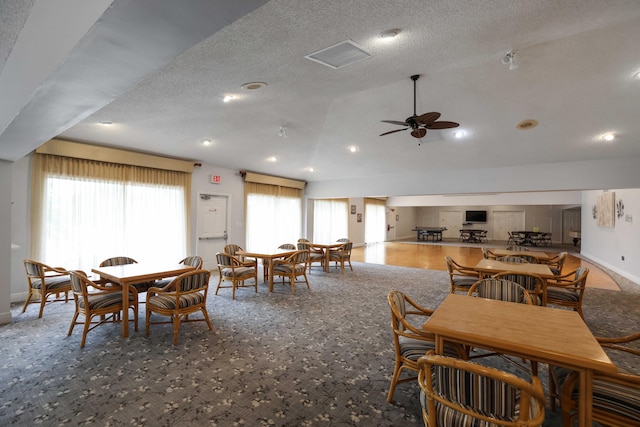 dining area featuring a textured ceiling, ceiling fan, and lofted ceiling