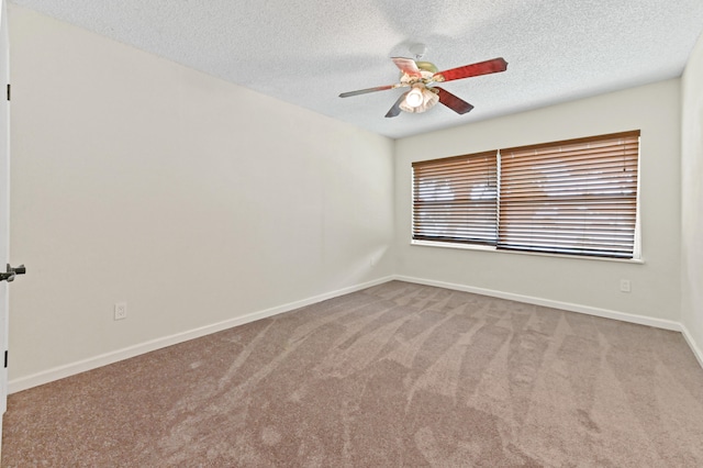 carpeted empty room with ceiling fan and a textured ceiling