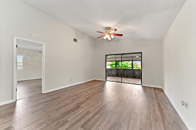 spare room with hardwood / wood-style floors, vaulted ceiling, ceiling fan, and a healthy amount of sunlight