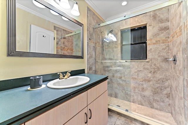 bathroom featuring tile patterned flooring, vanity, a tile shower, and crown molding