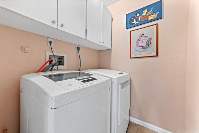 laundry area with washer and dryer, light tile patterned flooring, and cabinets