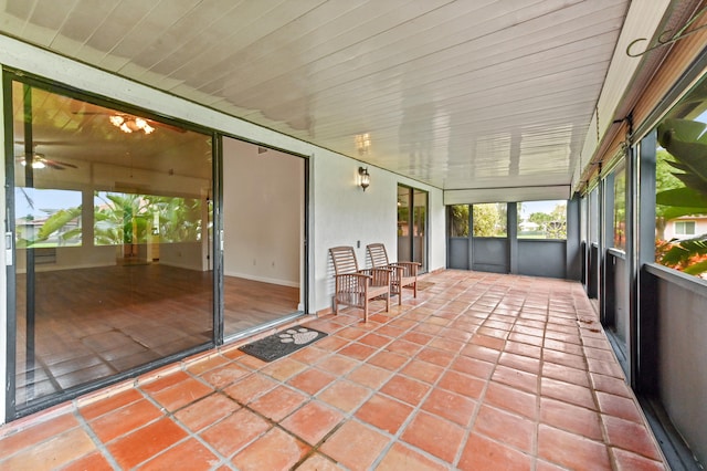 unfurnished sunroom featuring ceiling fan