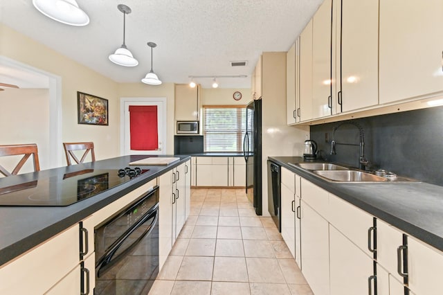 kitchen with pendant lighting, black appliances, sink, light tile patterned floors, and a textured ceiling