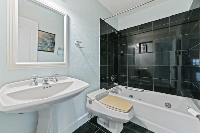 full bathroom with a textured ceiling, tiled shower / bath combo, sink, tile patterned flooring, and toilet