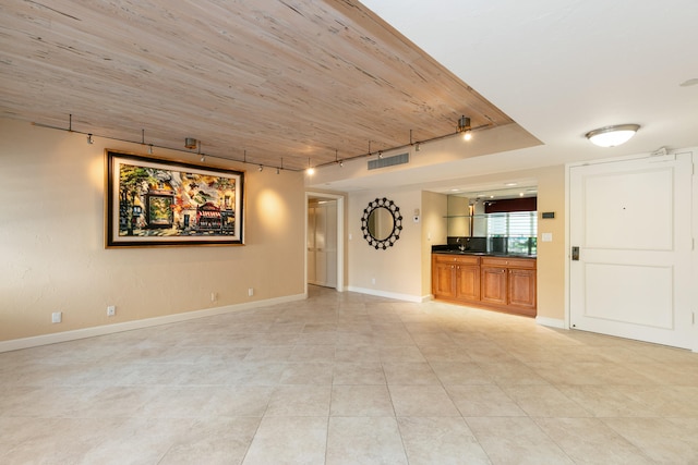 unfurnished living room with wooden ceiling, rail lighting, and light tile patterned floors