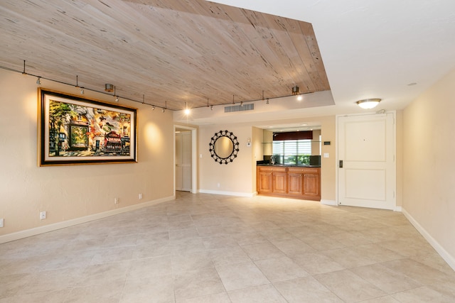 unfurnished living room featuring rail lighting, light tile patterned flooring, and wood ceiling