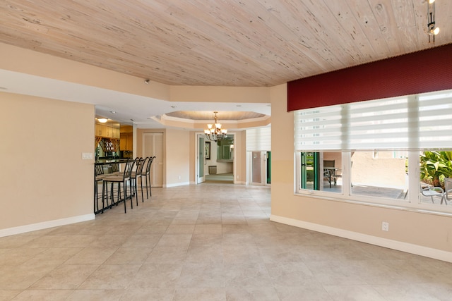 interior space with an inviting chandelier, a tray ceiling, wood ceiling, and light tile patterned floors