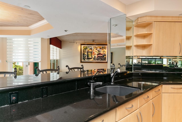 kitchen with wood ceiling, light brown cabinets, dark stone counters, crown molding, and sink