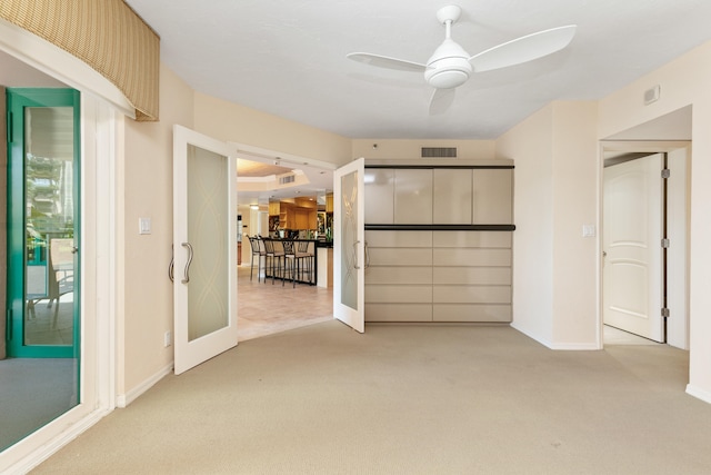 interior space featuring french doors, light carpet, and ceiling fan