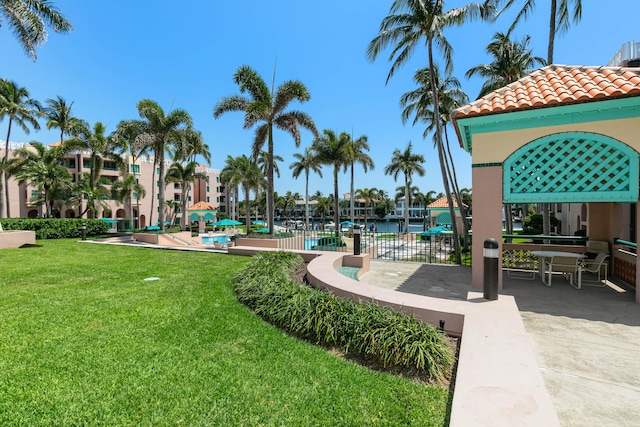 surrounding community with a water view, a yard, and a pool