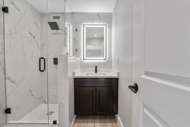 bathroom with vanity, wood-type flooring, and walk in shower