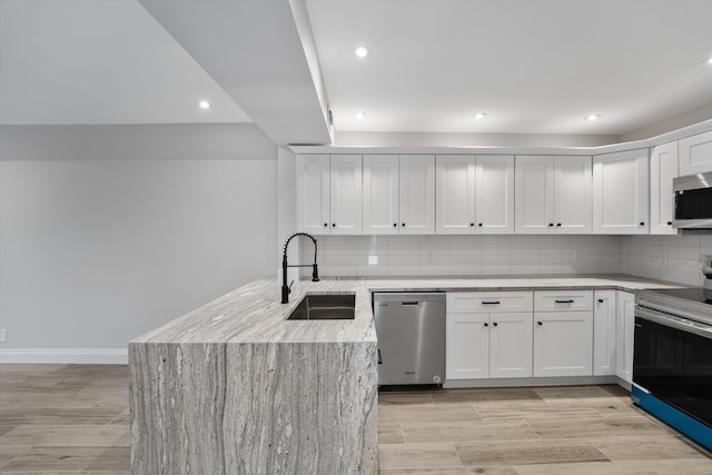 kitchen featuring white cabinetry, tasteful backsplash, appliances with stainless steel finishes, and sink