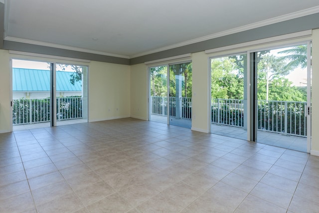 spare room featuring light tile patterned floors and ornamental molding