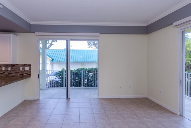 tiled empty room featuring ornamental molding and a healthy amount of sunlight