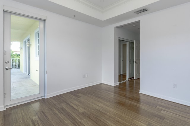 empty room featuring dark wood-type flooring and crown molding