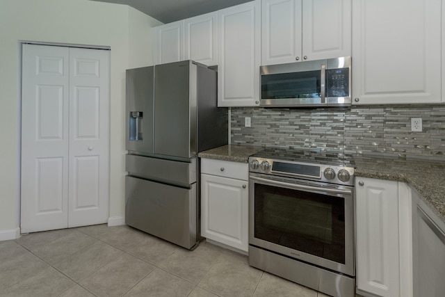 kitchen with white cabinetry, stainless steel appliances, and dark stone counters