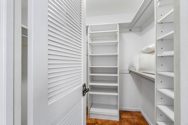 walk in closet featuring dark tile patterned flooring