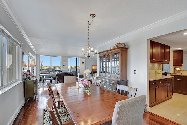 dining space featuring light hardwood / wood-style flooring, a chandelier, and crown molding