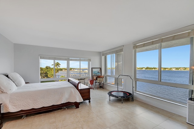 bedroom featuring light tile patterned flooring and a water view