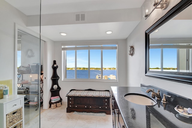 bathroom with vanity, a healthy amount of sunlight, a water view, and tile patterned flooring