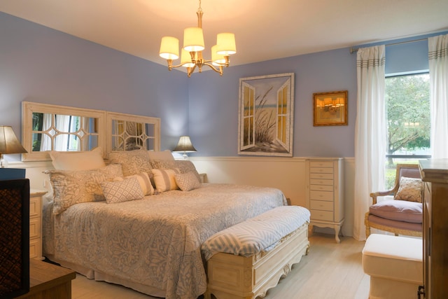 bedroom featuring an inviting chandelier and light hardwood / wood-style flooring