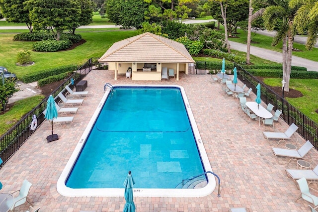 view of pool featuring a lawn and a patio