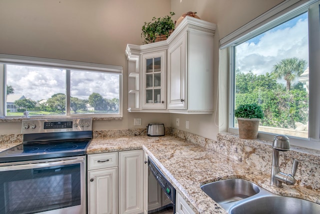 kitchen with white cabinets, black dishwasher, stainless steel range with electric cooktop, light stone countertops, and sink