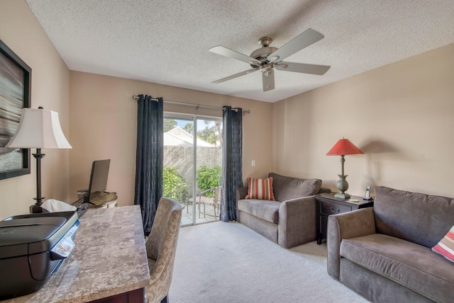 carpeted home office featuring a textured ceiling and ceiling fan