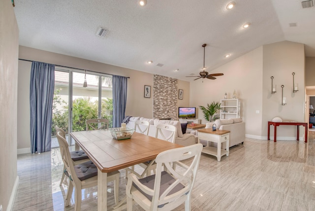 dining room with lofted ceiling, a textured ceiling, and ceiling fan