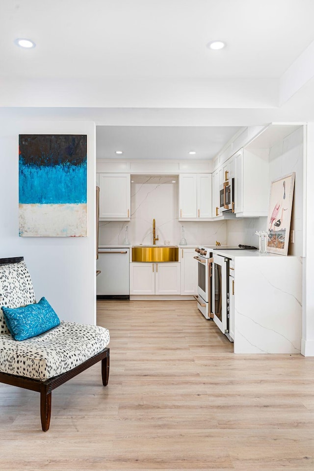 kitchen featuring white appliances, tasteful backsplash, white cabinetry, and sink