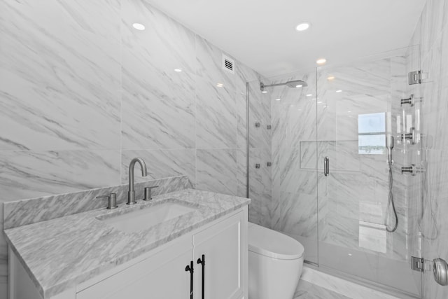 bathroom with vanity, toilet, and a shower with shower door