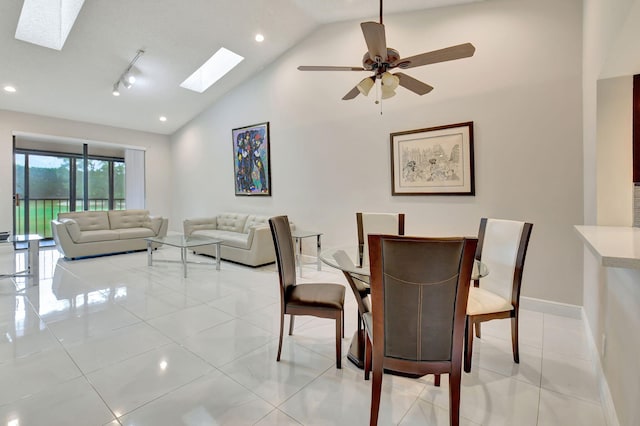 dining area featuring ceiling fan, high vaulted ceiling, a skylight, and light tile patterned floors