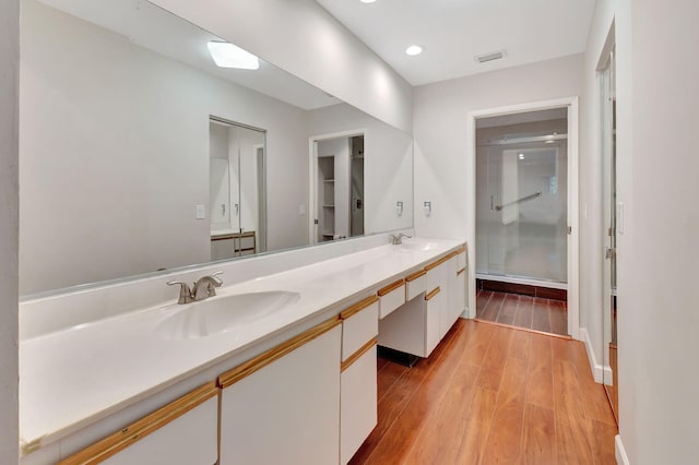 bathroom featuring a shower with door, vanity, and hardwood / wood-style flooring