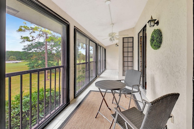 sunroom featuring ceiling fan and vaulted ceiling