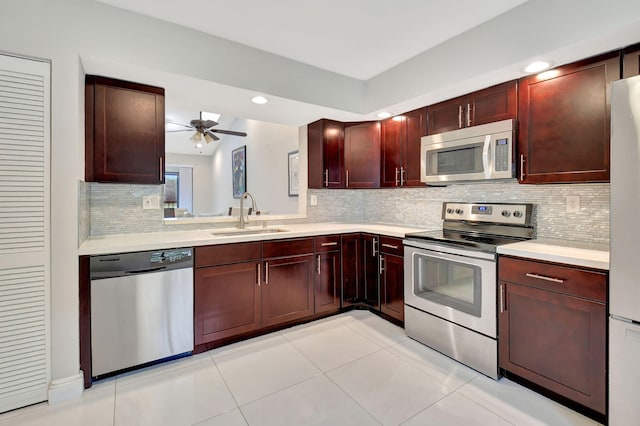 kitchen with sink, ceiling fan, light tile patterned floors, appliances with stainless steel finishes, and tasteful backsplash