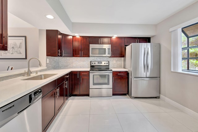 kitchen featuring sink, stainless steel appliances, backsplash, and light tile patterned floors