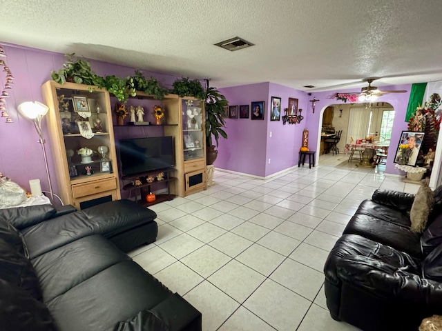 living room featuring ceiling fan, a textured ceiling, and light tile patterned flooring