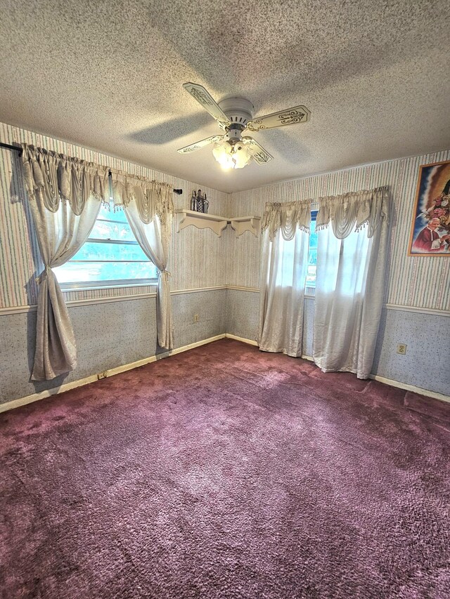 275 SE 16th Ave, Okeechobee, FL 34974 - empty room with wallpapered walls, dark colored carpet, a textured ceiling, a ceiling fan, and baseboards