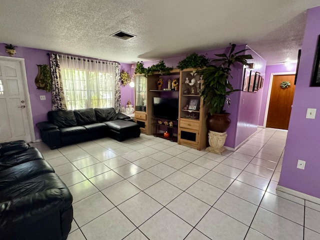 living room with a textured ceiling and light tile patterned floors