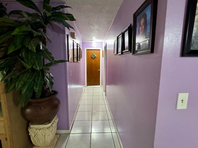 hallway featuring a textured ceiling and light tile patterned flooring