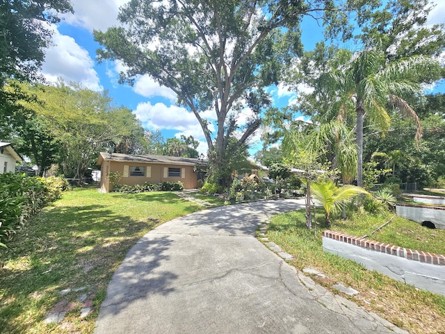 275 SE 16th Ave, Okeechobee, FL 34974 - view of front of house featuring a front yard, asphalt driveway, and stucco siding