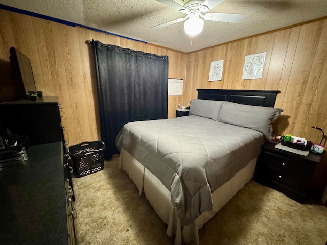 carpeted bedroom featuring a textured ceiling, wooden walls, and ceiling fan