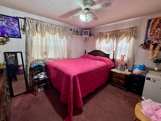 carpeted bedroom featuring ceiling fan and a textured ceiling