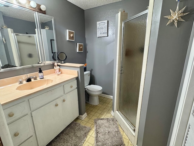 bathroom with vanity, a shower with shower door, a textured ceiling, and toilet