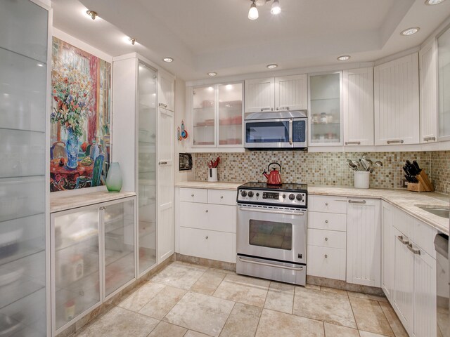 kitchen with white cabinets, stainless steel appliances, and tasteful backsplash