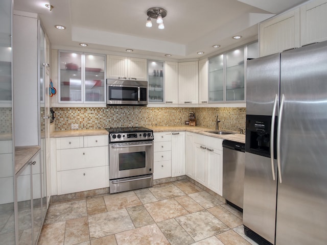 kitchen featuring backsplash, sink, white cabinets, and stainless steel appliances