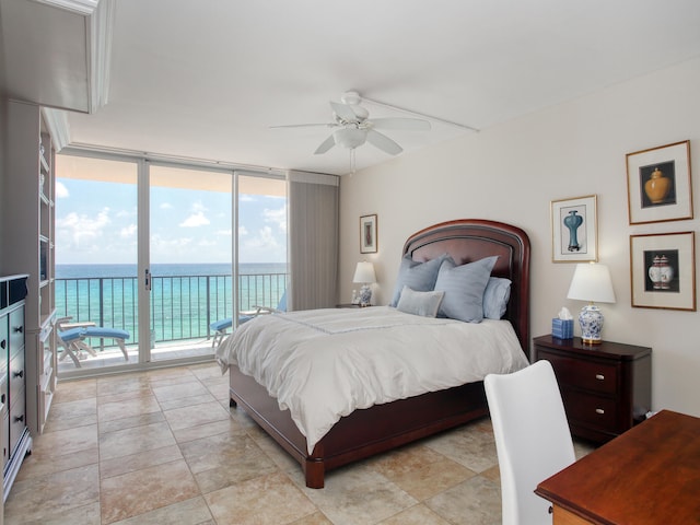 bedroom with access to outside, ceiling fan, a water view, and a wall of windows