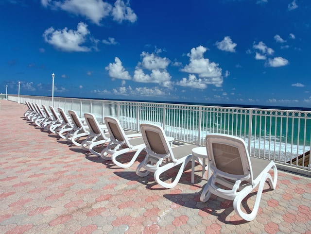 view of patio / terrace featuring a water view and a view of the beach